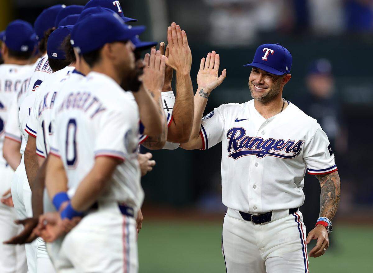 Texas Rangers manager Skip Schumaker high-fives players before the start of their home opener against the Cincinnati Reds on Friday, April 3, 2026.