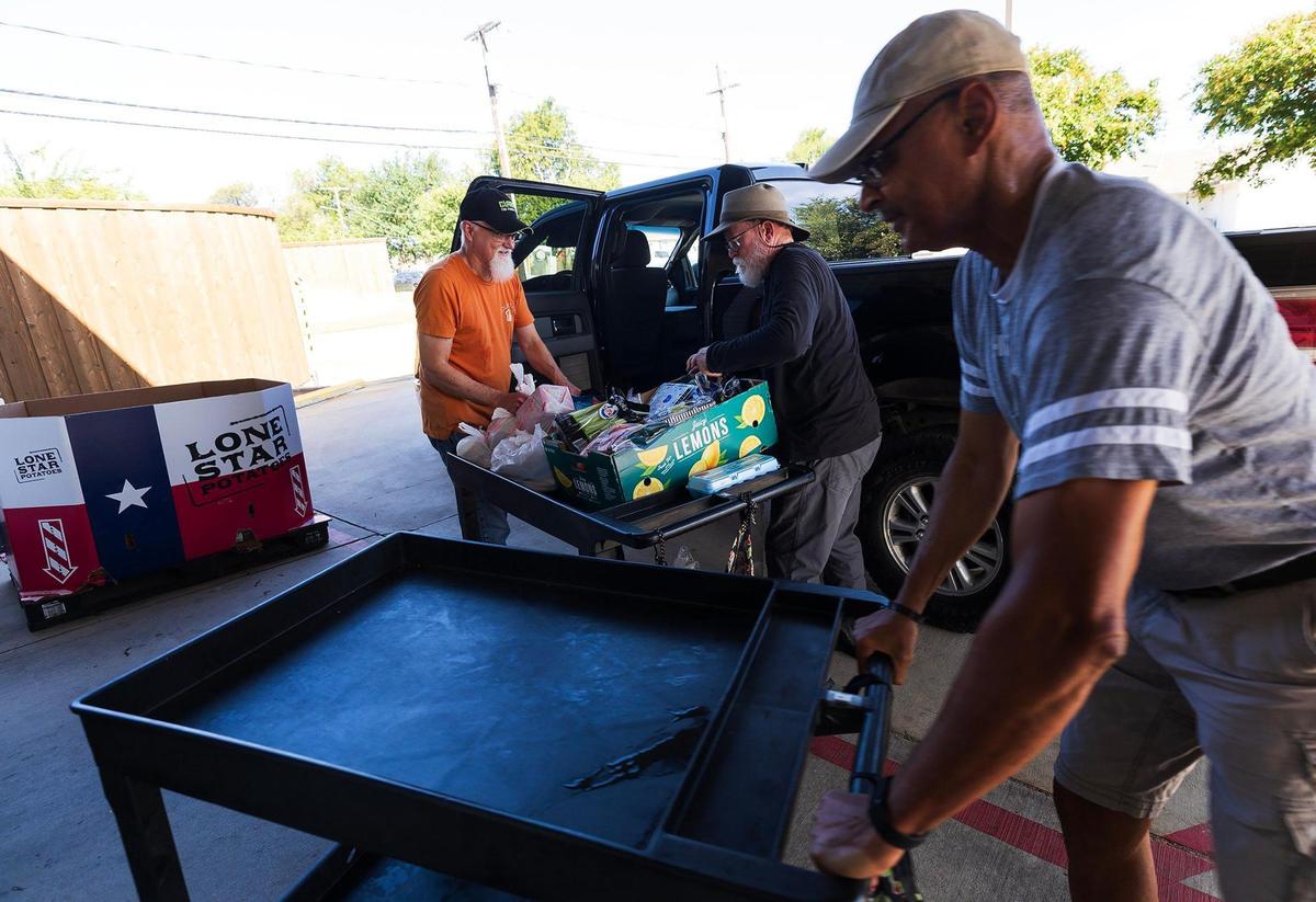 Volunteers at Community Link load load groceries from their food pantry into vehicles on Tuesday, July 22, 2025, in Saginaw.