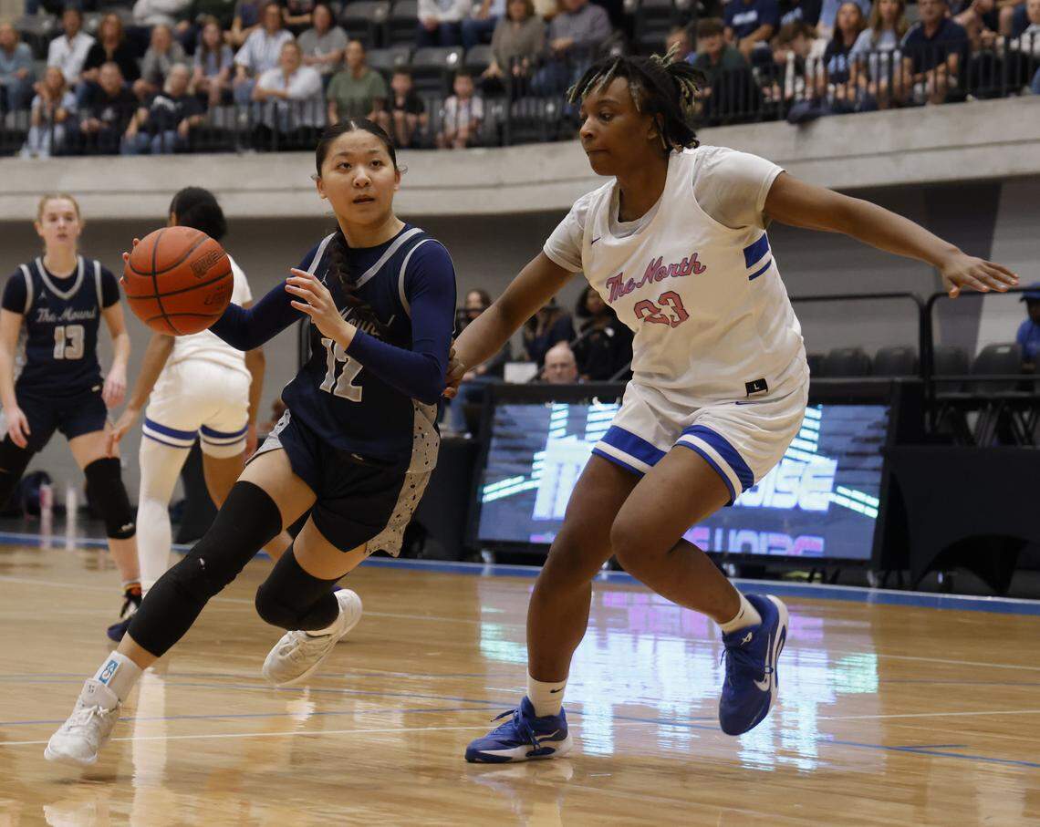 Flower Mound guard Emily Tran (12) turns the corner on North Crowley forward Mecca Crawford (23) during the first half of a UIL Class 6A Division I girls regional final basketball playoff game at Arlington ISD Athletics Center in Arlington, Texas, Friday Feb. 27, 2026.
