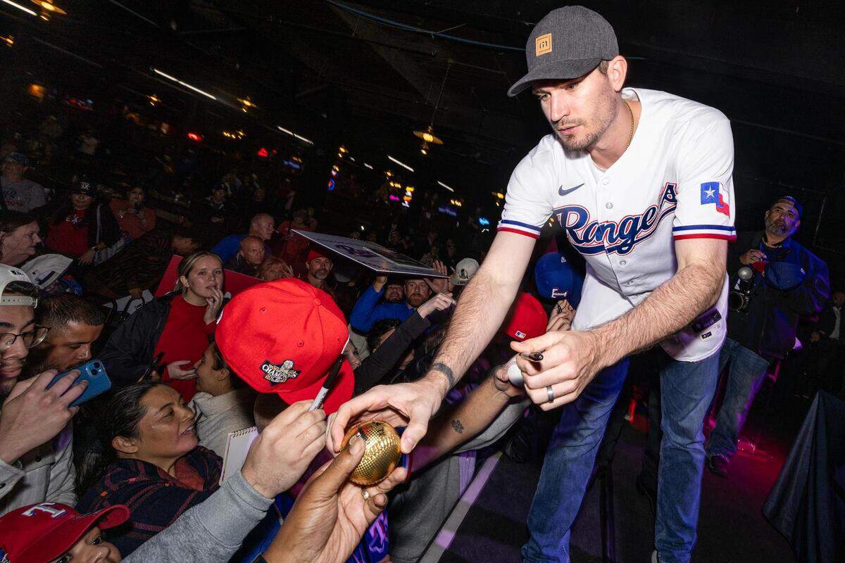 Texas Rangers pitcher Andrew Heaney signs memorabilia with fans during a Rangers World Series celebration event at Billy Bob’s Texas in Fort Worth on Thursday, Nov. 9, 2023.