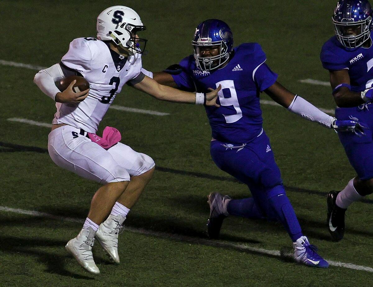 All Saints quarterback Hampton Fay tries to avoid Nolan defensive lineman Curlee Thomas (9) during the second half of a high school football game, October 16, 2020 played at Doskocil Staduim at Nolan High School in Fort Worth, Tx. (Steve Nurenberg Special to the Star-Telegram)
