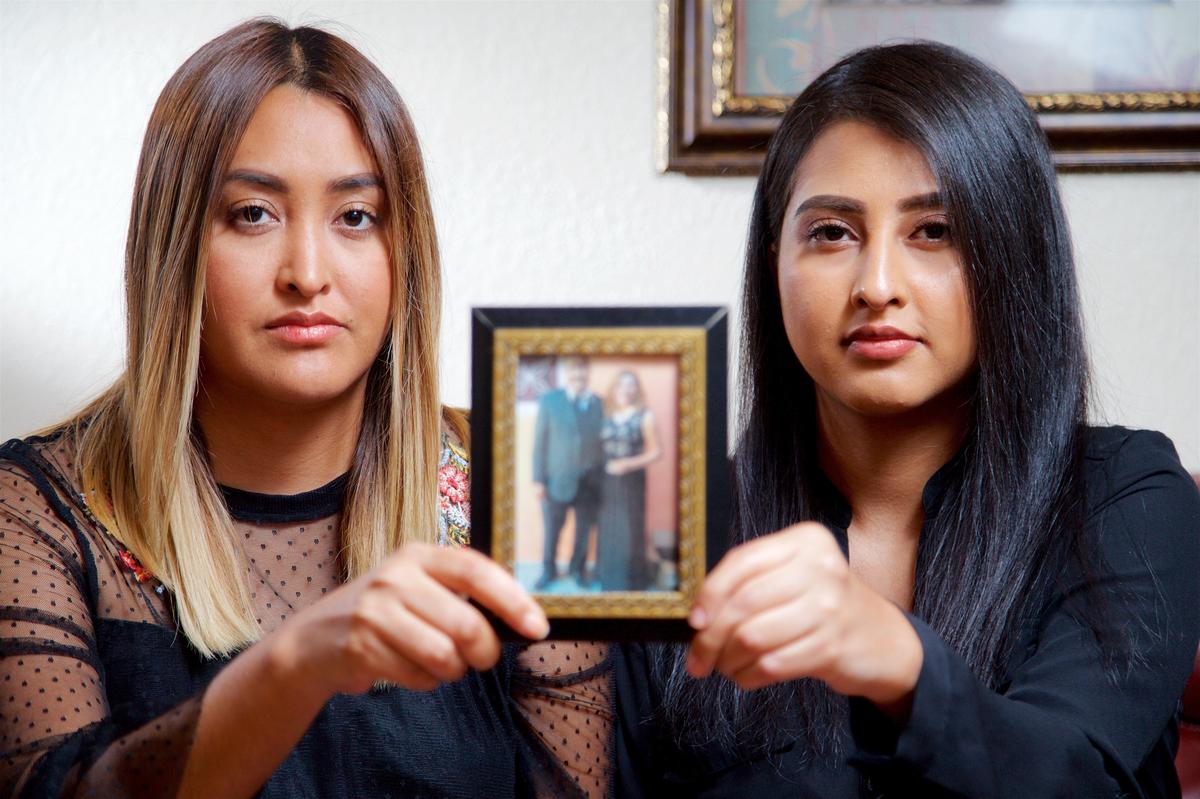 Jessica, left, and Stephanie Ramirez, hold a photo of their mom and dad in Haltom City, Tuesday, May 8, 2018.