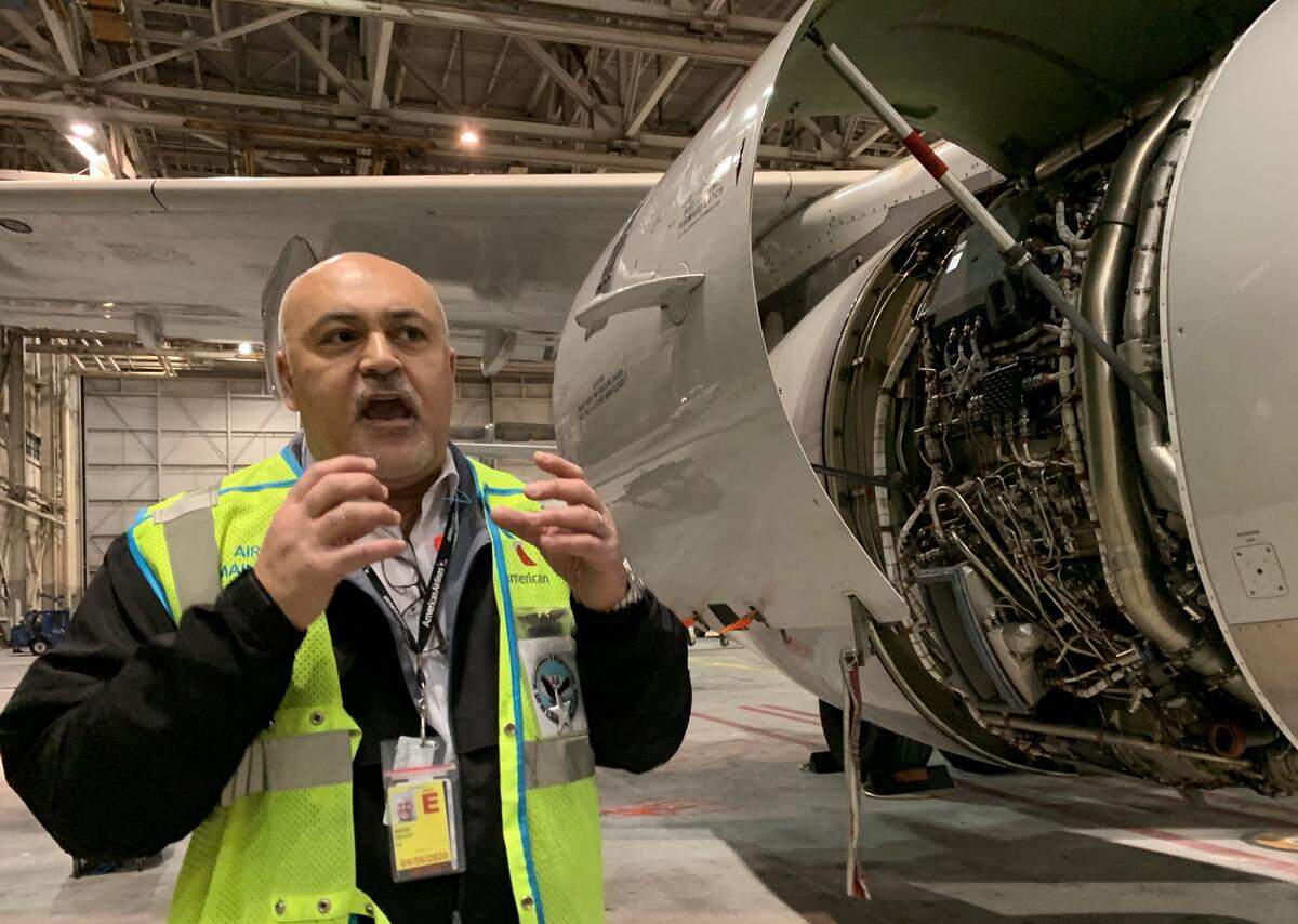 Badih Delati, American Airlines aircraft maintenance manager, explains some of the work being done on a jet engine.
