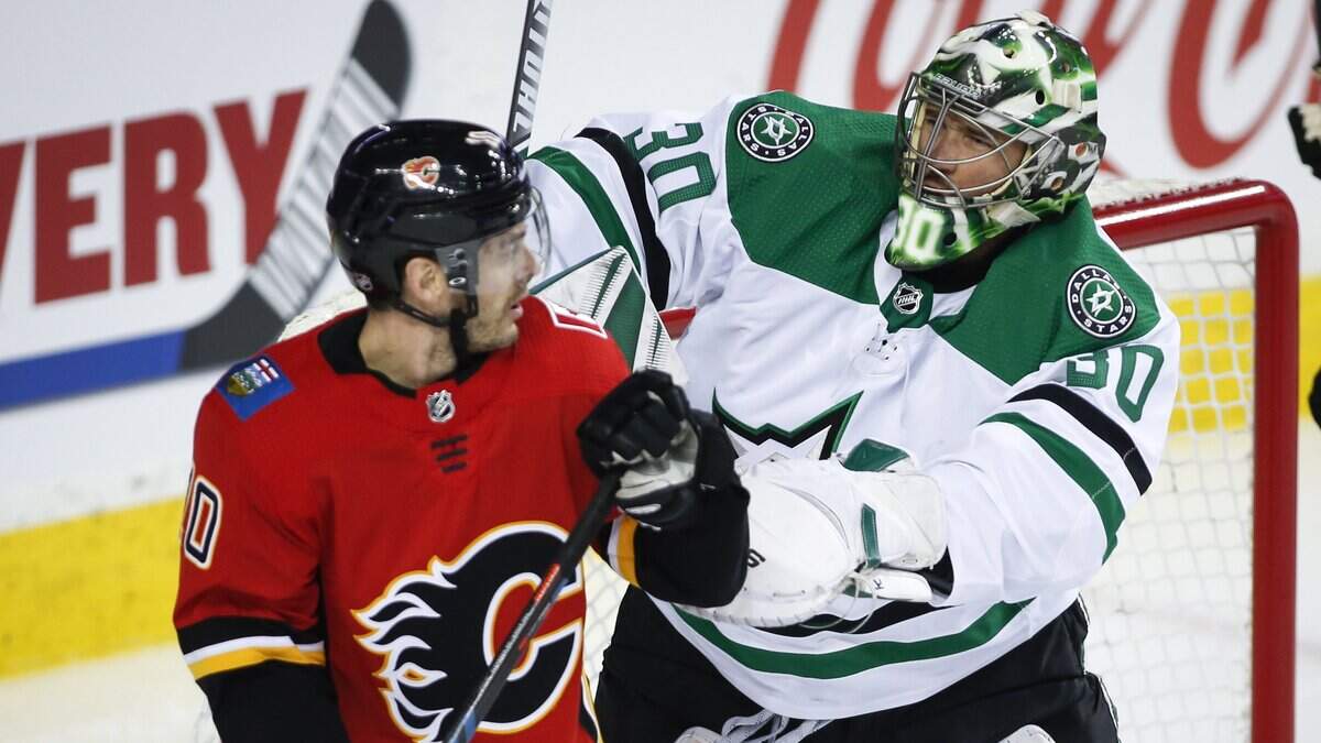 Dallas Stars goalie Ben Bishop, right, shoves Calgary Flames’ Derek Ryan away from the net during the first period of an NHL hockey game Wednesday, March 27, 2019, in Calgary, Alberta. (Jeff McIntosh/The Canadian Press via AP)