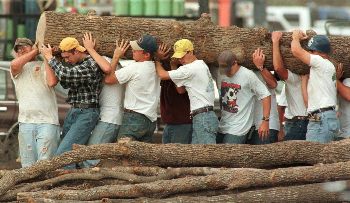 Student volunteers carry logs from the fallen bonfire that collapsed at Texas A&M in College Station, killing 12, on Nov. 18, 1999.