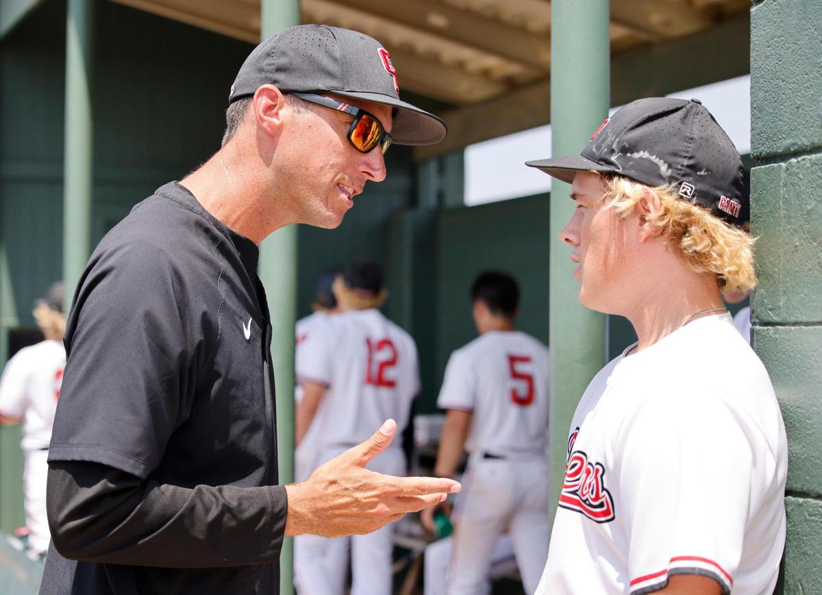 Colleyville Heritage head coach Chris McMullen talks to third baseman Regan Kelley (8) in the dugout during the UIL baseball regional final 5A D1 playoff game at Hawk Baseball Field in North Richland Hills, Texas, Thursday, May 22, 2025.
