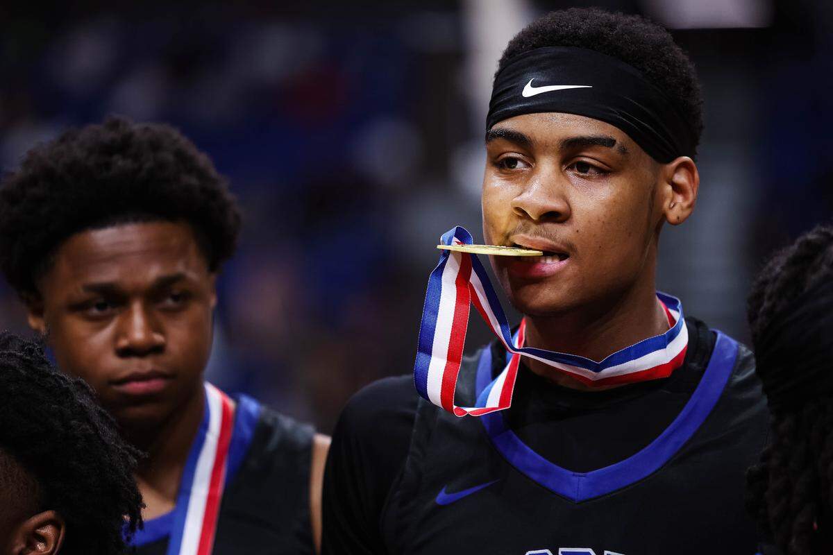 North Crowley forward Trey Hall (11) holds the championship gold medal in his mouth after winning the Class 6A Division I state championship game against San Antonio Brennan on Saturday at the Alamodome in San Antonio.