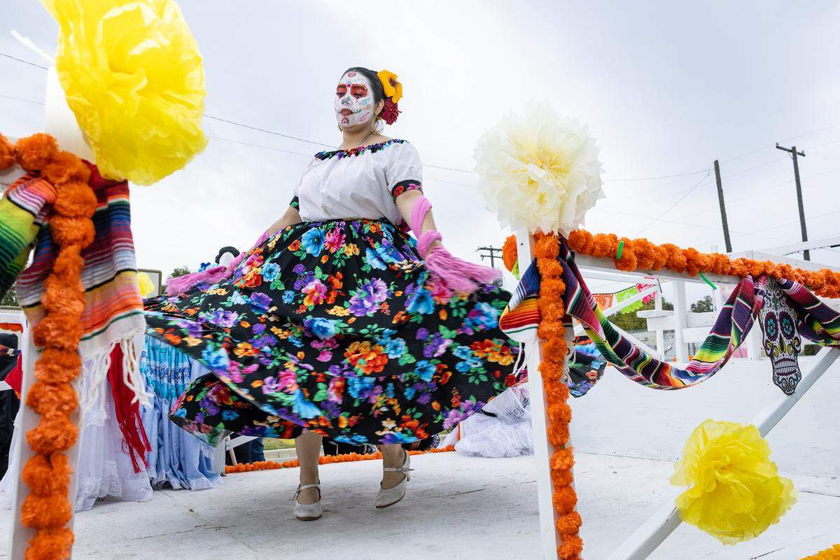 A parade participant from Ballet Folklorico de Fort Worth dances on their float on Ellis Avenue for the Dia De Los Muertos Parade in Northside Fort Worth on Saturday, Nov. 1, 2025.