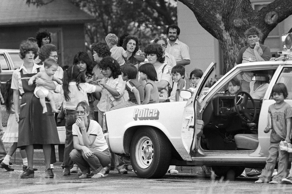 Dozens of neighbors look on as officials seize a jaguar from the home of Karen Louise Hobbs in Fort Worth, 1982.  