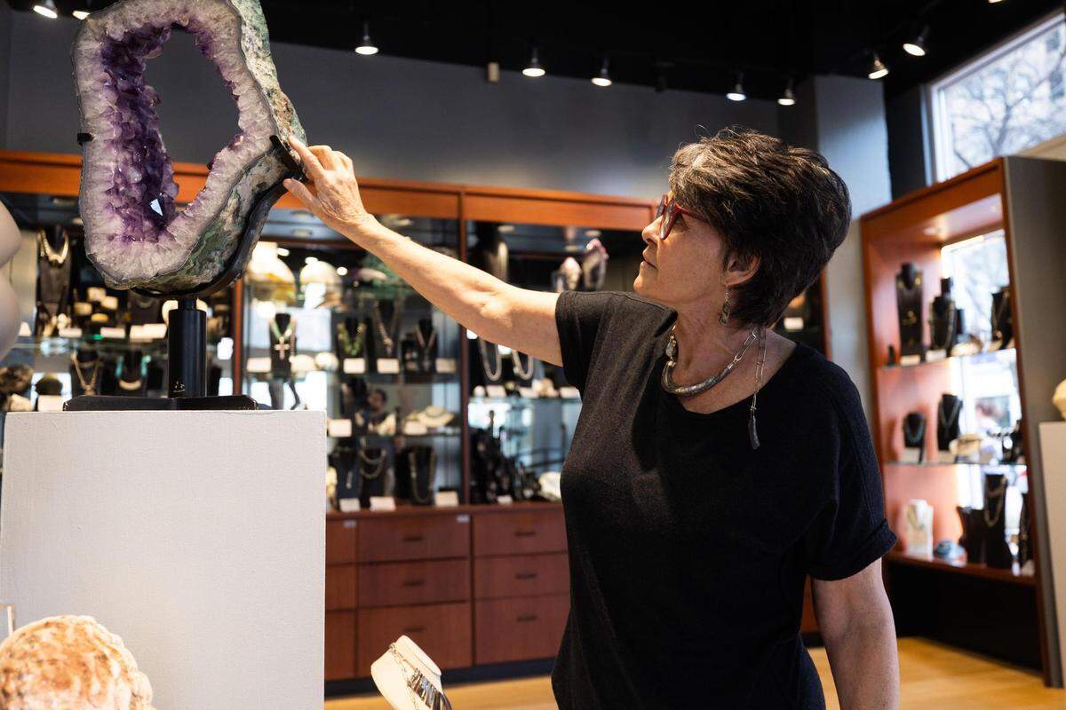 Cary O’Keefe points out details in an amethyst on display in her shop in Sundance Square in downtown Fort Worth.