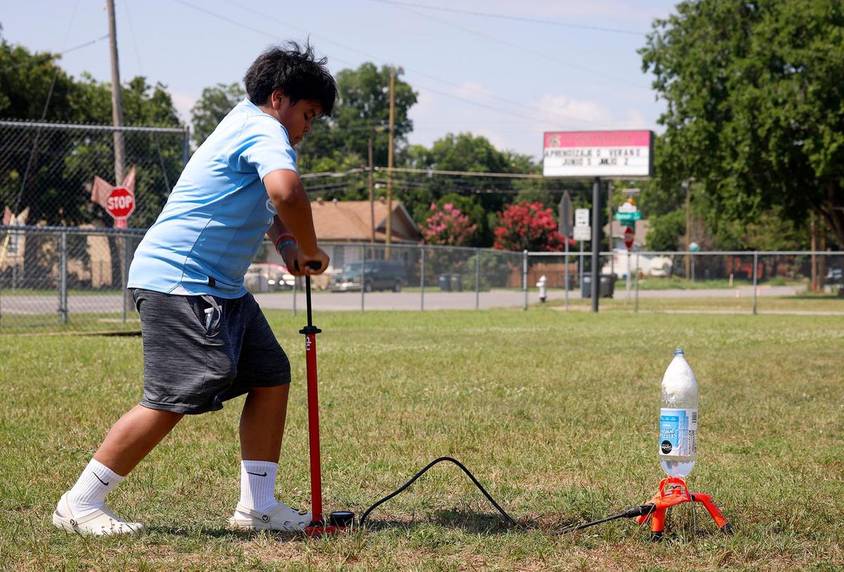 Marcos Puente Osorio pumps water into a soda bottle rocket engineered by a classmate during an enrichment camp at Rufino Mendoza Elementary School on June 12 in Fort Worth.