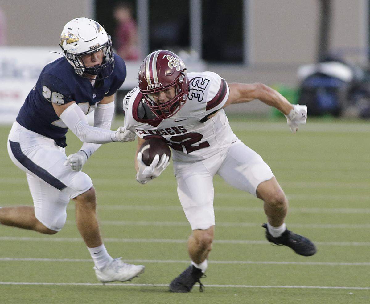 Keller Central’s Spencer Martin (23) is caught in the grasp of Keller’s Cody Fouts (26) during their game at Keller ISD Athletic Complex on Friday, Sep. 26, 2025.
