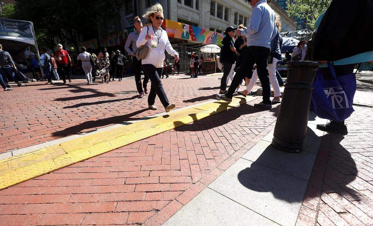 Pedestrians cross West 4th Street while visiting the Main Street Arts Festival and the Fort Worth Art Fair on Friday in downtown Fort Worth.