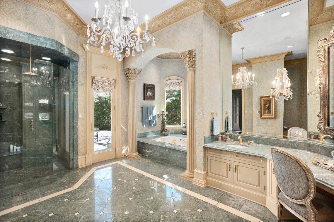The primary owner’s bathroom includes marble flooring and a chandelier. (Interluxe Auctions)