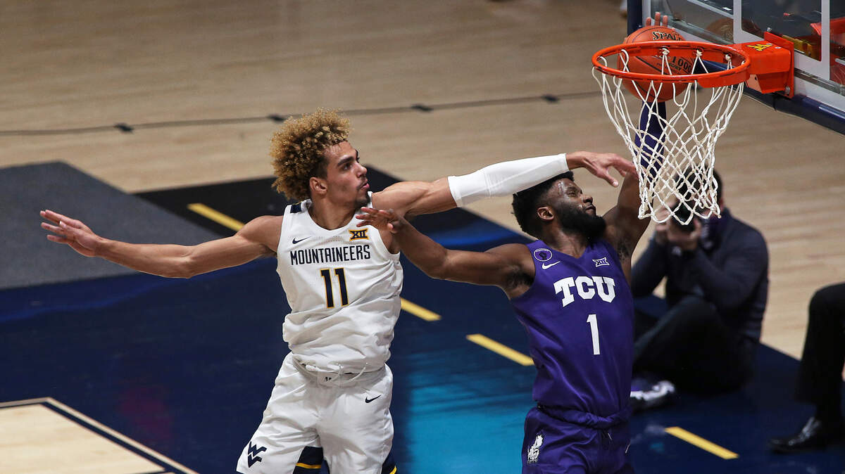 TCU guard Mike Miles (1) shoots while defended by West Virginia forward Emmitt Matthews Jr. (11) during the first half of Thursday’s game in Morgantown, W.Va.