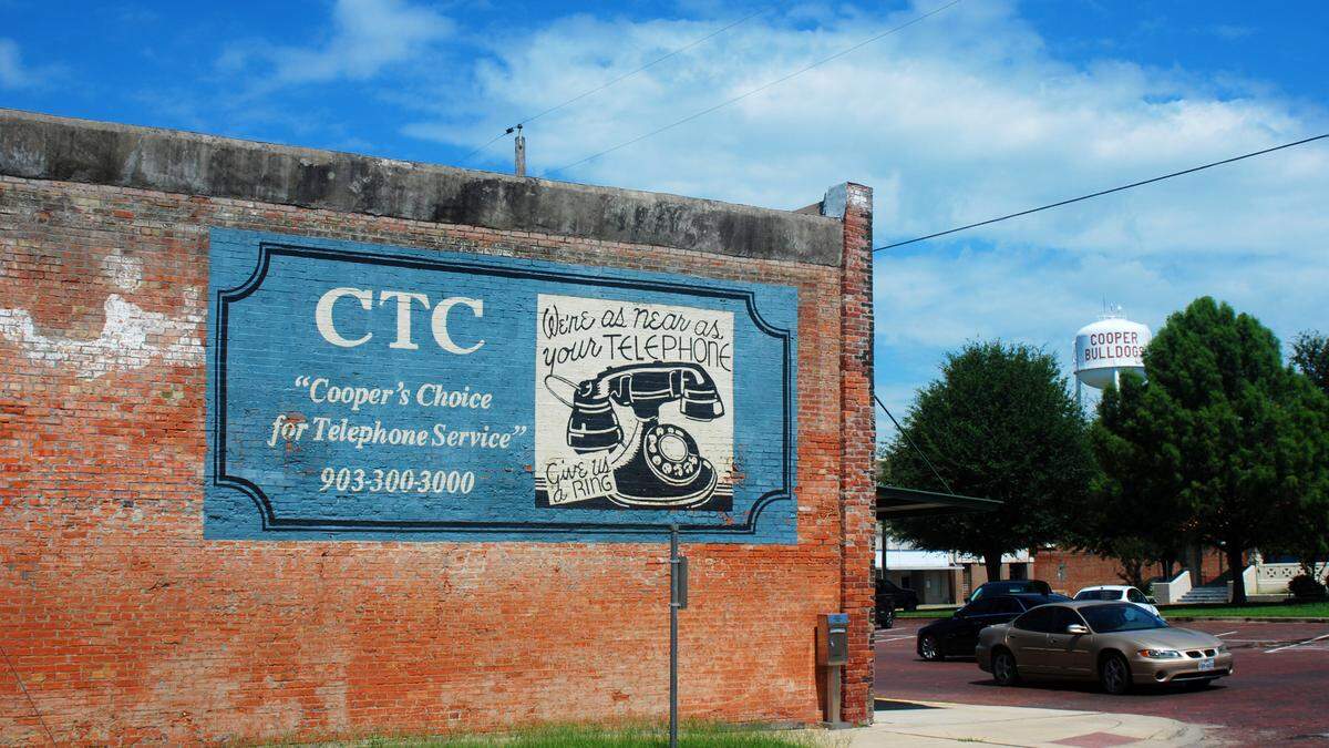 Cars pass storefronts lining the main square of Cooper, Texas, in tiny Delta County, some 120 miles northeast of Forth Worth, on July 13, 2019.