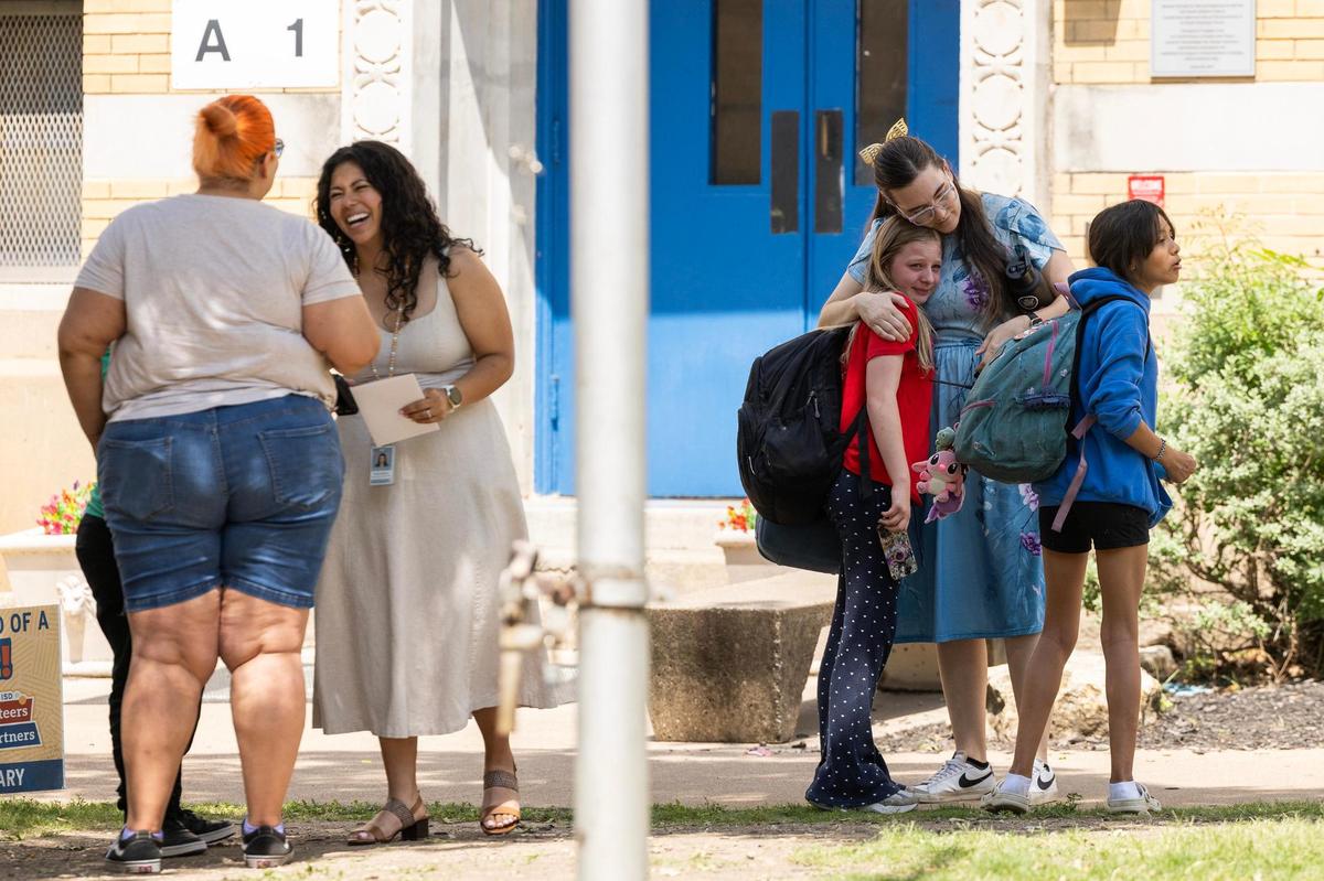 School administrators hug students goodbye after their final day of the school year at De Zavala Elementary School in Fort Worth on May 22.