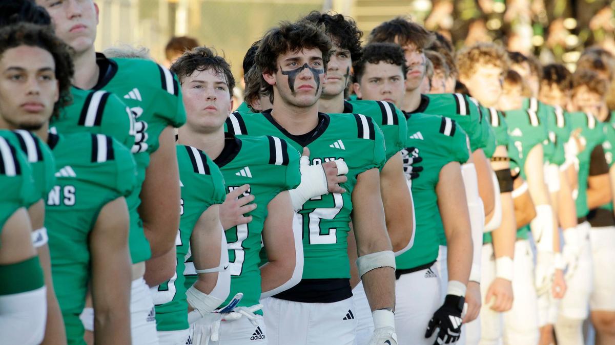Southlake Carroll’s Rex Duggan (82) and the rest of the Dragons listen to the playing of the National Anthem during a UIL football game at Dragon Stadium on Friday, Sept. 27, 2024.