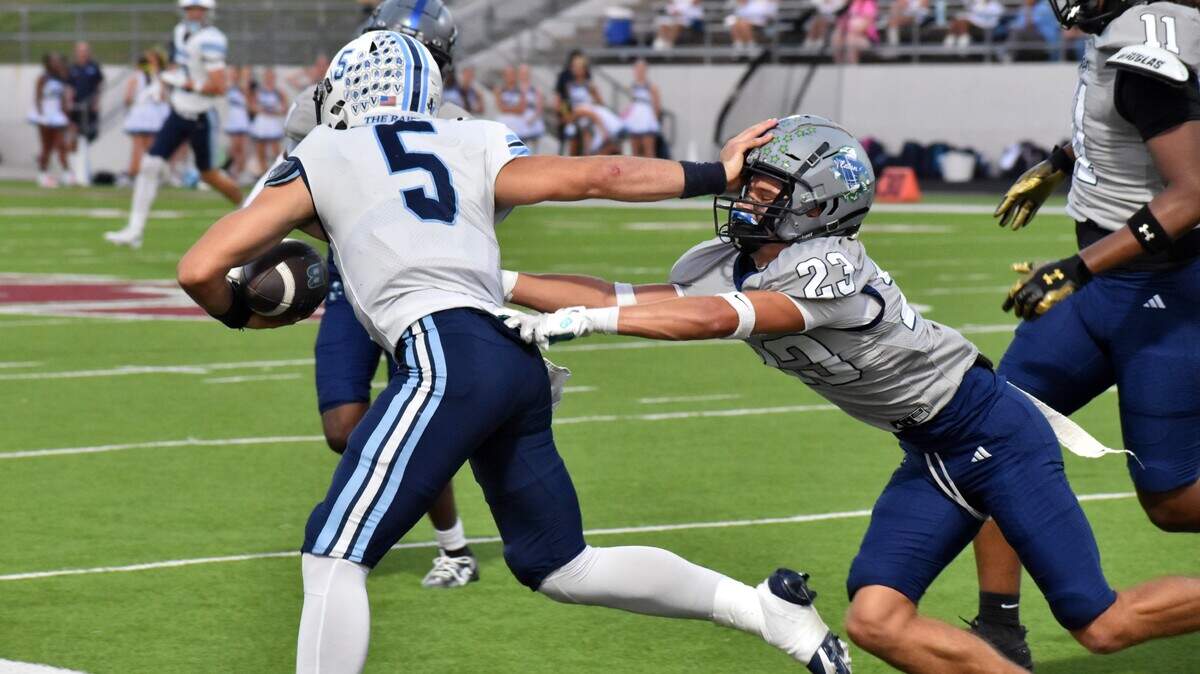 Hurst LD Bell quarterback Braylon Harris (5) stiff-arms Haslet V.R. Eaton tackler Ramsey Villareal in the first quarter of a UIL high school football Class 6A game at Northwest ISD Stadium in Justin on Friday, Sept. 26, 2025.