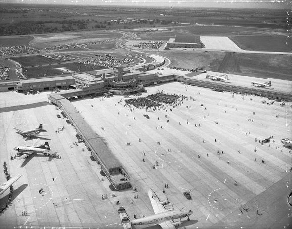 The terminal with its runways and planes parked on the tarmac, with vast undeveloped land in the background.