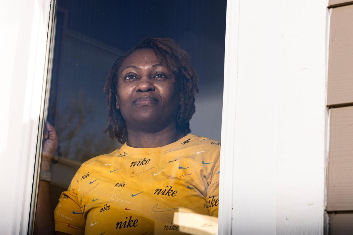 Smith looks out the back window of her new home. “I’ve been sleeping comfortably,” she said of the stability the home offered her and her family.