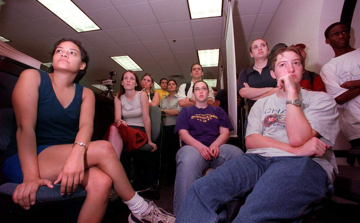 On a lone TV in UTA’s Hereford Center, Martina Santesteban, Kerri Cornell and David Hudspeth watch a broadcast of terrorist attacks on the morning of Sept. 11.