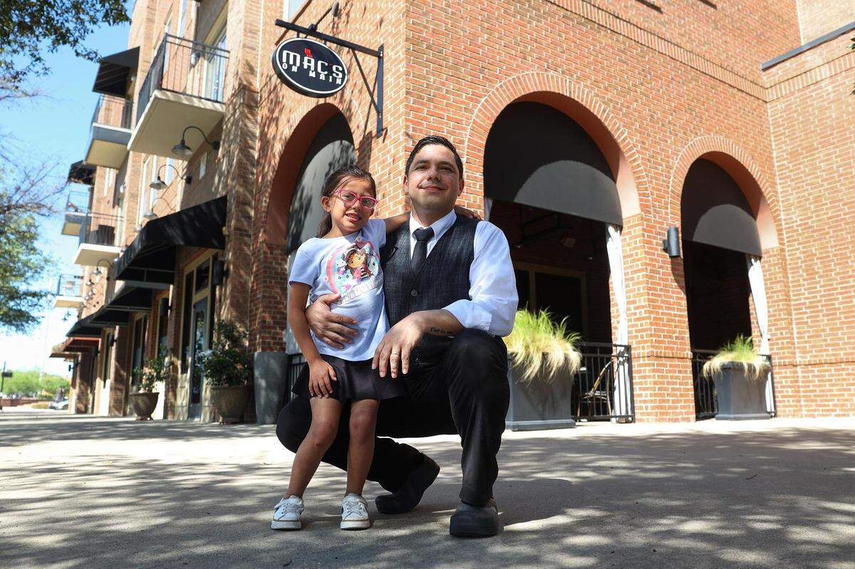 Juan Cordova and his daughter, Camila, 6, in front of Mac’s on Main, his place of employment, on Friday, April 5 in Grapevine. The full price of child care became too expensive for his family without financial aid, Cordova said, and now he and his wife — who is also a server — work opposite shifts and rely on relatives to make their child care situation work.