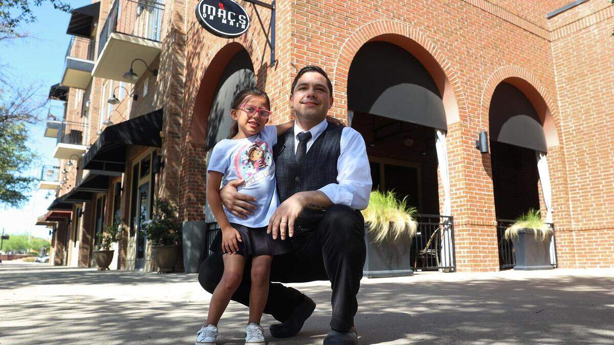 Juan Cordova and his daughter, Camila, 6, in front of Mac’s on Main, his place of employment, on April 5, 2024, in Grapevine. A child care task force is creating a legislative agenda advocating for better child care policies. Mac’s on Main is among businesses in the food industry involved in this task force.