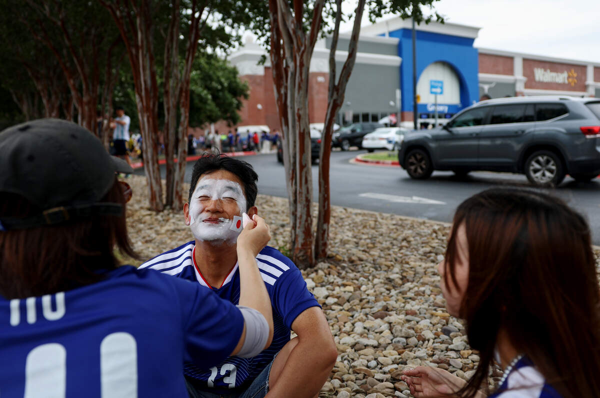 Japan fans prepare for the FIFA World Cup 2026 group stage match against Sweden by painting their faces at a nearby Walmart parking lot on Thursday, June 25, 2026, in Arlington.