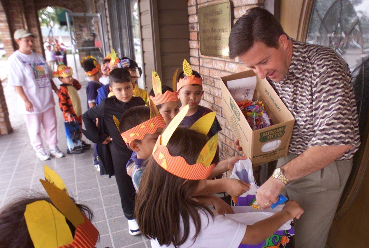 2001: Eight classes of first-graders from Speer Elementary walk to Town North Shopping Center to trick or treat the stores, a 40-year tradition. Bryan Craven with Simplex Management Corp. hands out candy.