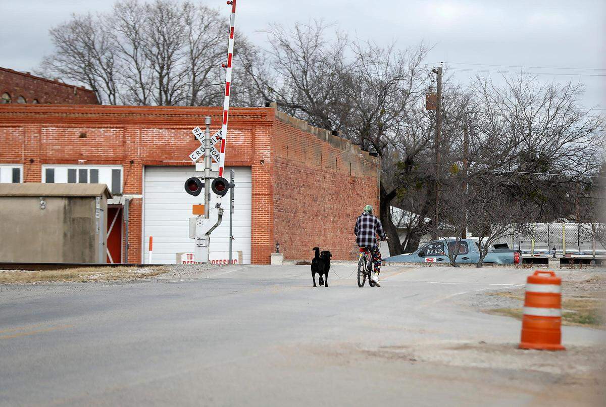 A man and his dog make their way down Texas Highway 16 in downtown Strawn.