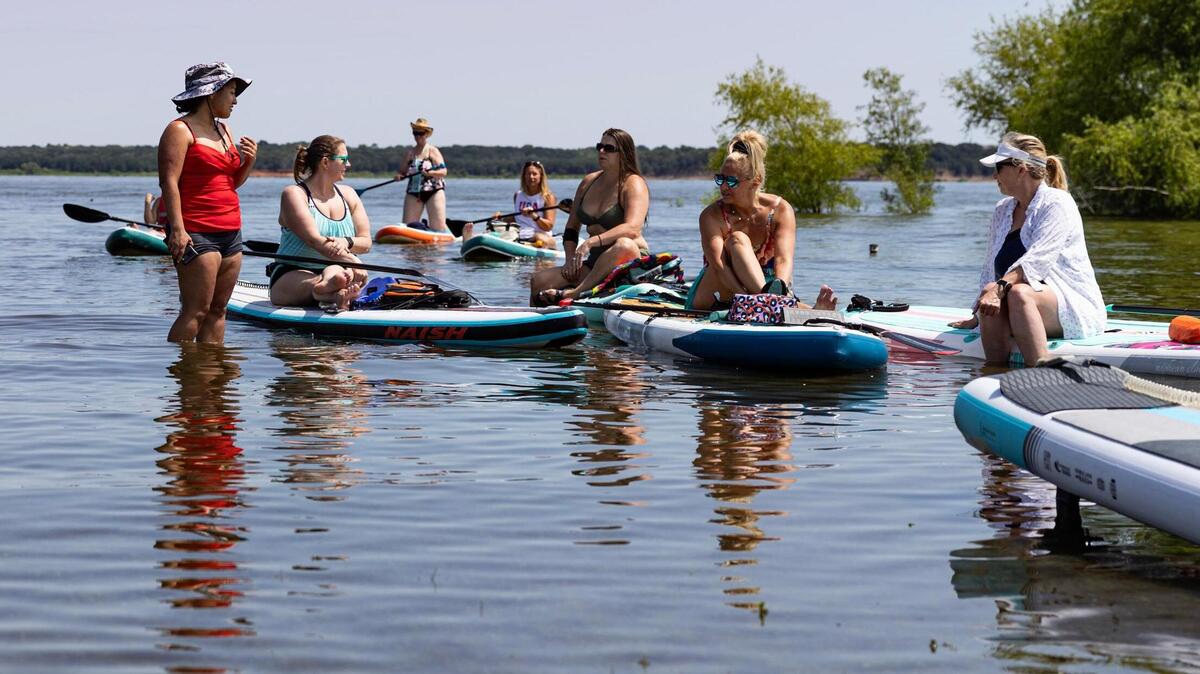 A group of kayakers and paddle boarders make their way back to the shore at Oak Grove Park near Grapevine Lake in Grapevine on Saturday, May 30, 2025.