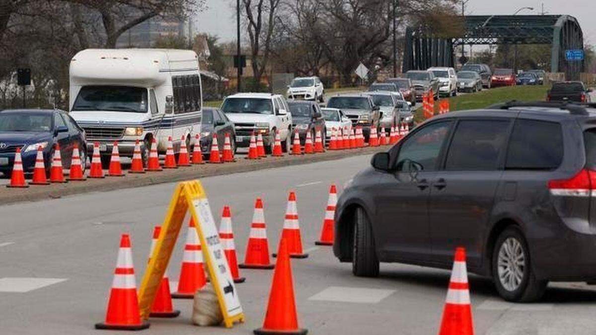 Traffic lined up in a row next to orange cones