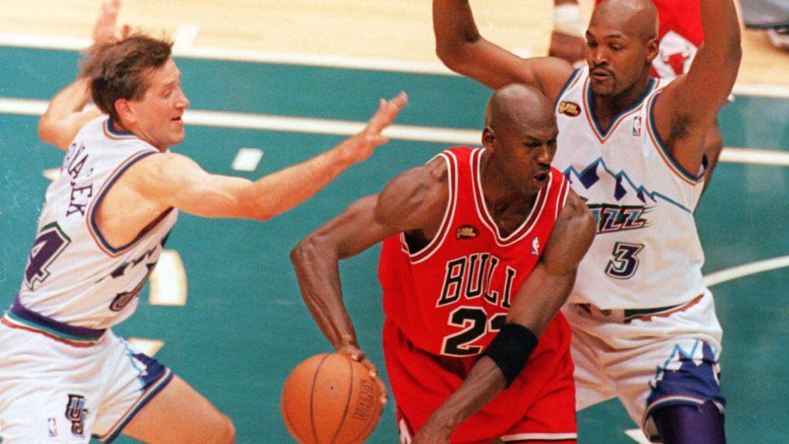 Utah Jazz’s Jeff Hornacek, left, tries to steal the ball from Chicgo Bulls’ Michael Jordan as Jazz’s Bryon Russell, right, defends in the second half of Game 6 of the NBA Finals in Salt Lake City, Sunday, June 14, 1998. Jordan was named MVP as the Bulls went on to win 87-86 and their third straight NBA title. (AP Photo/Douglas C. Pizac)