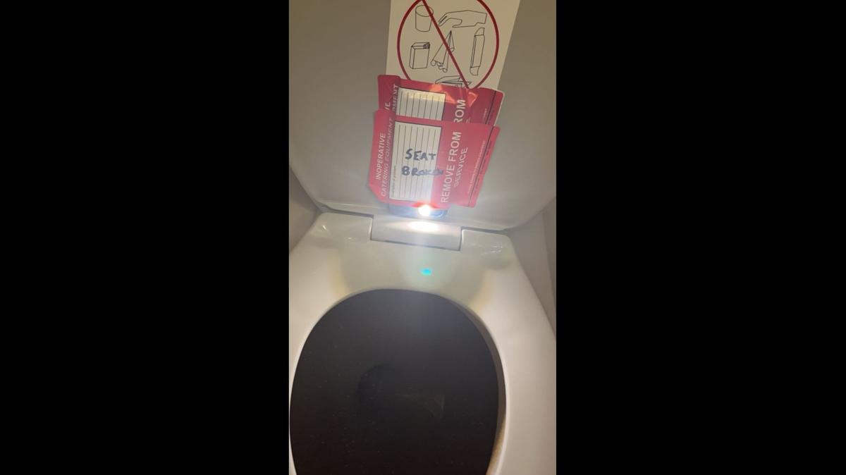 This photo shows a phone allegedly hidden on a lavatory seat on an American Airlines plane by flight attendant Estes Carter Thompson III, who faces federal charges.
