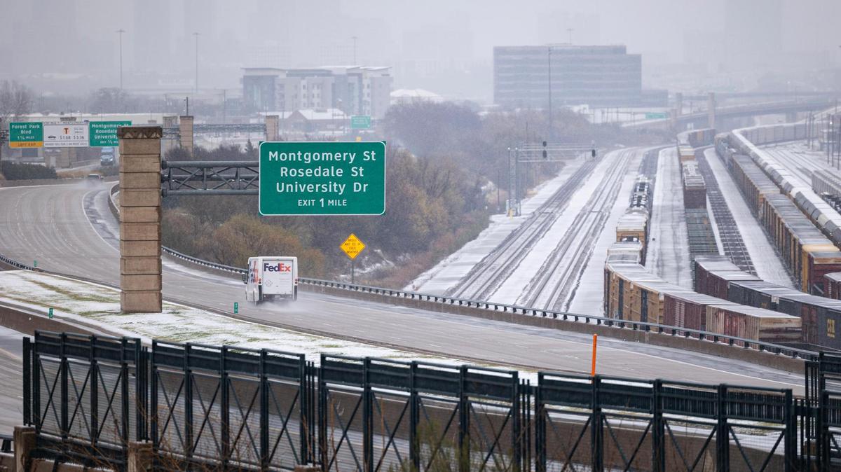 Snow covers the cargo trains and railroad behind the Chisholm Trail Tollway in Fort Worth on Thursday, Jan. 9, 2025.
