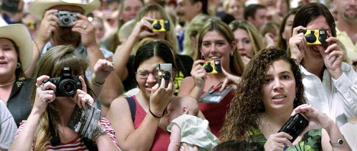 Elbow to elbow fans of country singer Toby Keith including Vickie Mendez, bottom right, of Wylie, pulled out their cameras to get a shot of the entertainer at the Wal-Mart in North Richland Hills on July 28, 2002.