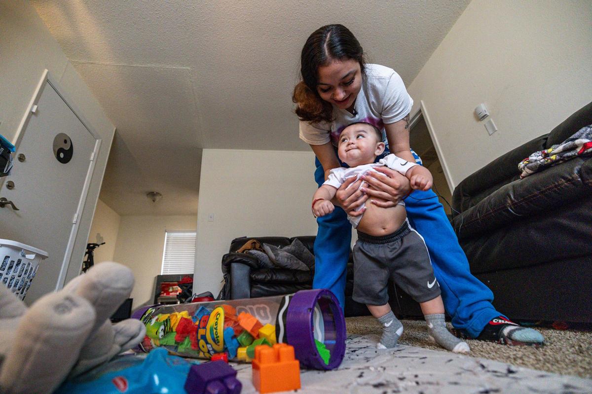 Corina Camacho helps her son, Zechariah Emilio, learn to walk at her apartment in Fort Worth in April. She was pregnant when her boyfriend, Zechariah Trevino, was shot to death in January 2023.