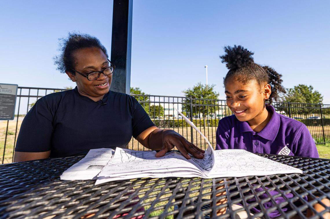 LaShanta Mire, left, helps her daughter Malaysia Campbell, 8, build her reading skills at the park in the Patriot Pointe Apartments in Fort Worth on Wednesday. After taking a reading assessment over the summer, Campbell was told she has a kindergarten reading level as a third grader despite coming home with A’s on her report cards.