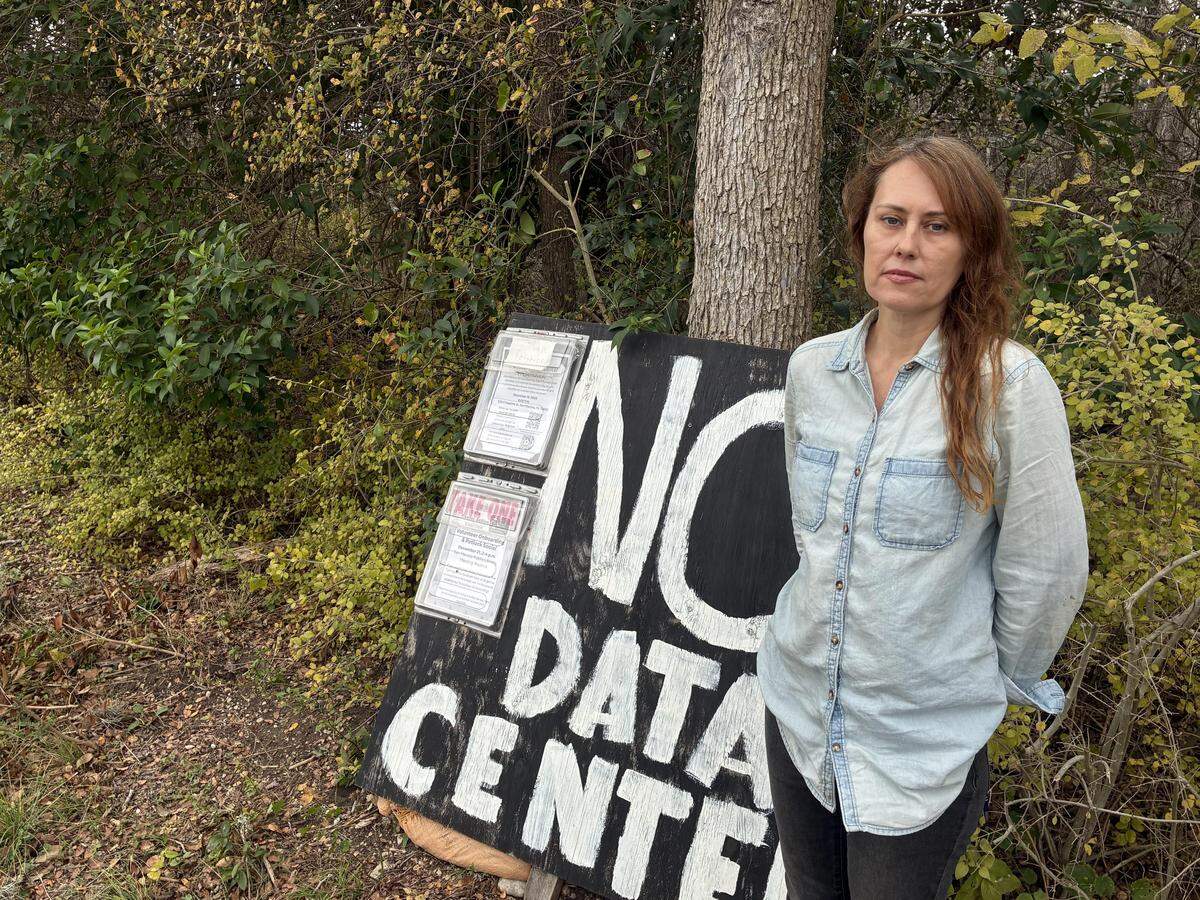 Abigail Lindsey stands next to a sign opposing data centers near her home in Hays County on Dec. 12.
