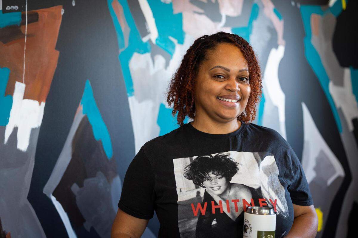 Owner Mia Moss in front of a mural inside Black Coffee Friday, June 24, 2022, in Fort Worth.