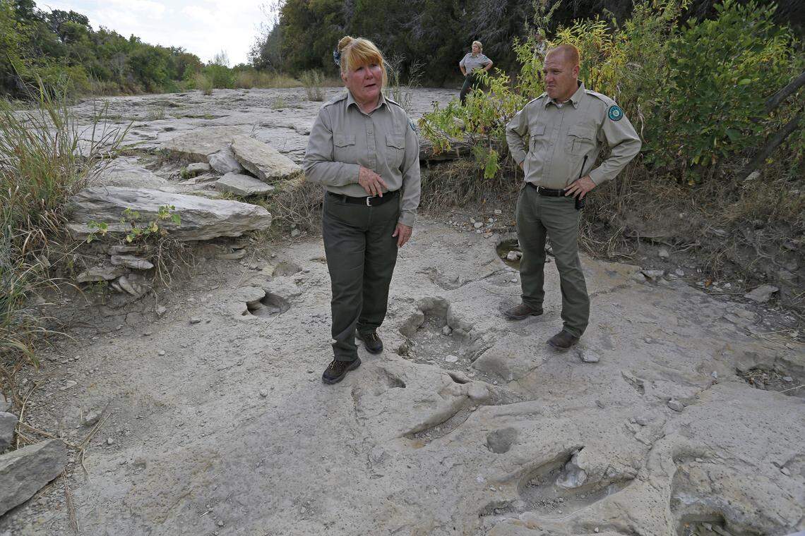 Kathy Lenz (left) and Jason Sanchez (right) in the Bird Track Site with dinosaur imprints at their feet.