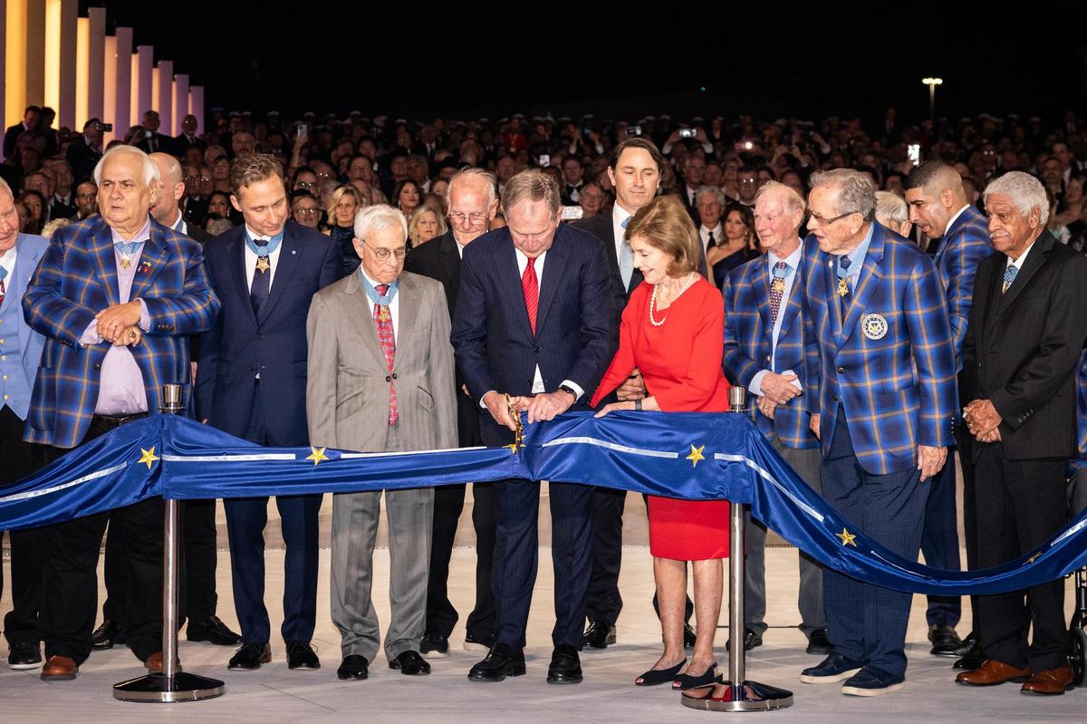 President George W. Bush cuts the ribbon surrounded by Medal of Honor recipients during the ribbon cutting portion of the National Medal of Honor Museum Grand Opening Celebration in the Arlington Entertainment District on Saturday, March 22, 2025.