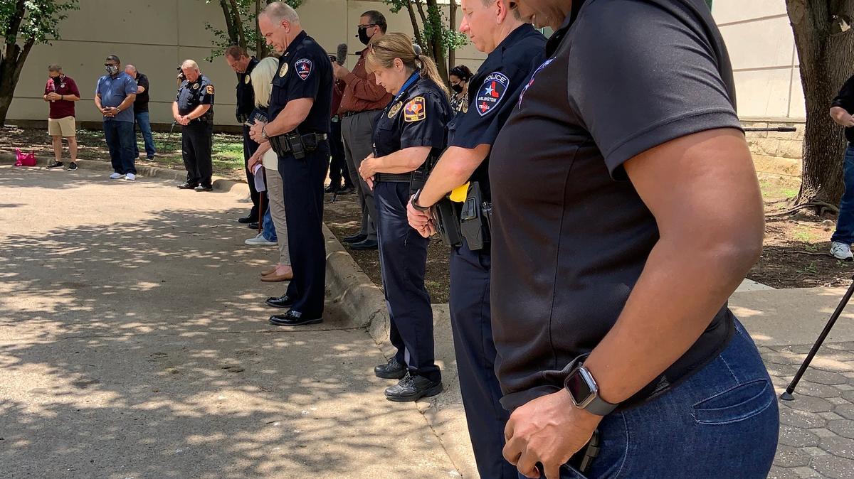 Arlington Police officers pray at the Arlington Police Station on Tuesday. The prayer for peace was led by the Arlington Clergy and Police Partnership.