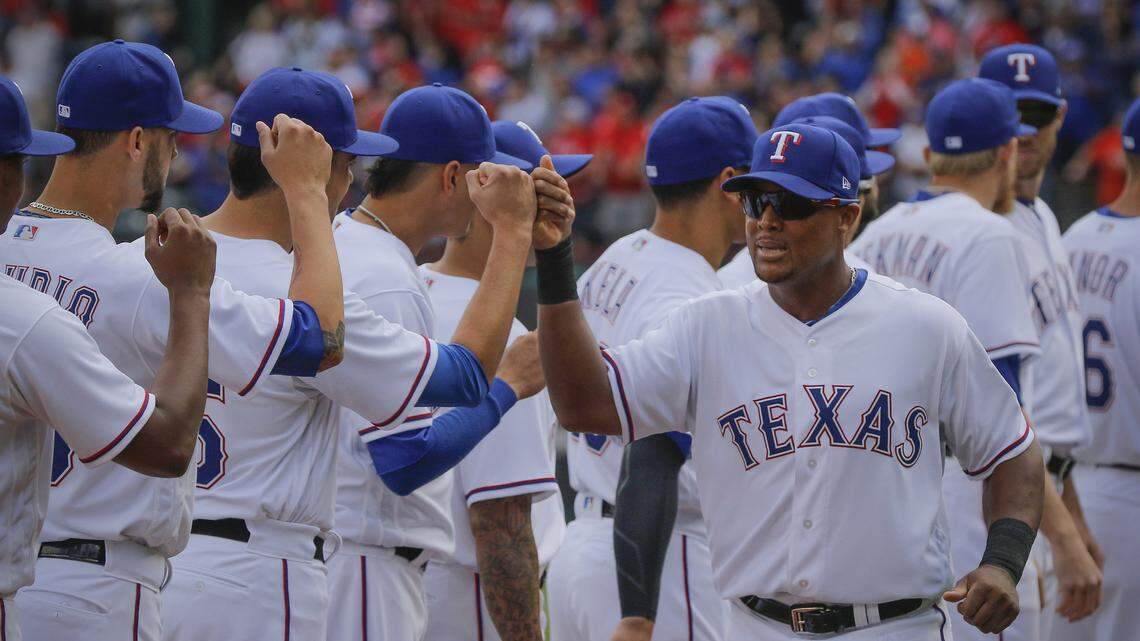 Adrian Beltre fist bumps his Rangers teammates during player introductions on Opening Day Thursday at Globe Life Park.