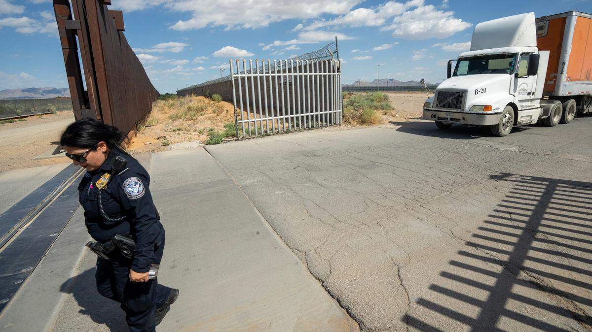 A U.S. Customs and Border Protection Chief Cecilia Esparza walks past the border wall while Mexican truck drivers await entry from San Jeronimo, Mexico (right) to Santa Teresa, New Mexico on . About 700 trucks from Mexico use this port of entry daily. Foxconn, the Taiwan-based manufacturer of personal computers and computer components built the plant across the border San Jeronimo, Mexico.