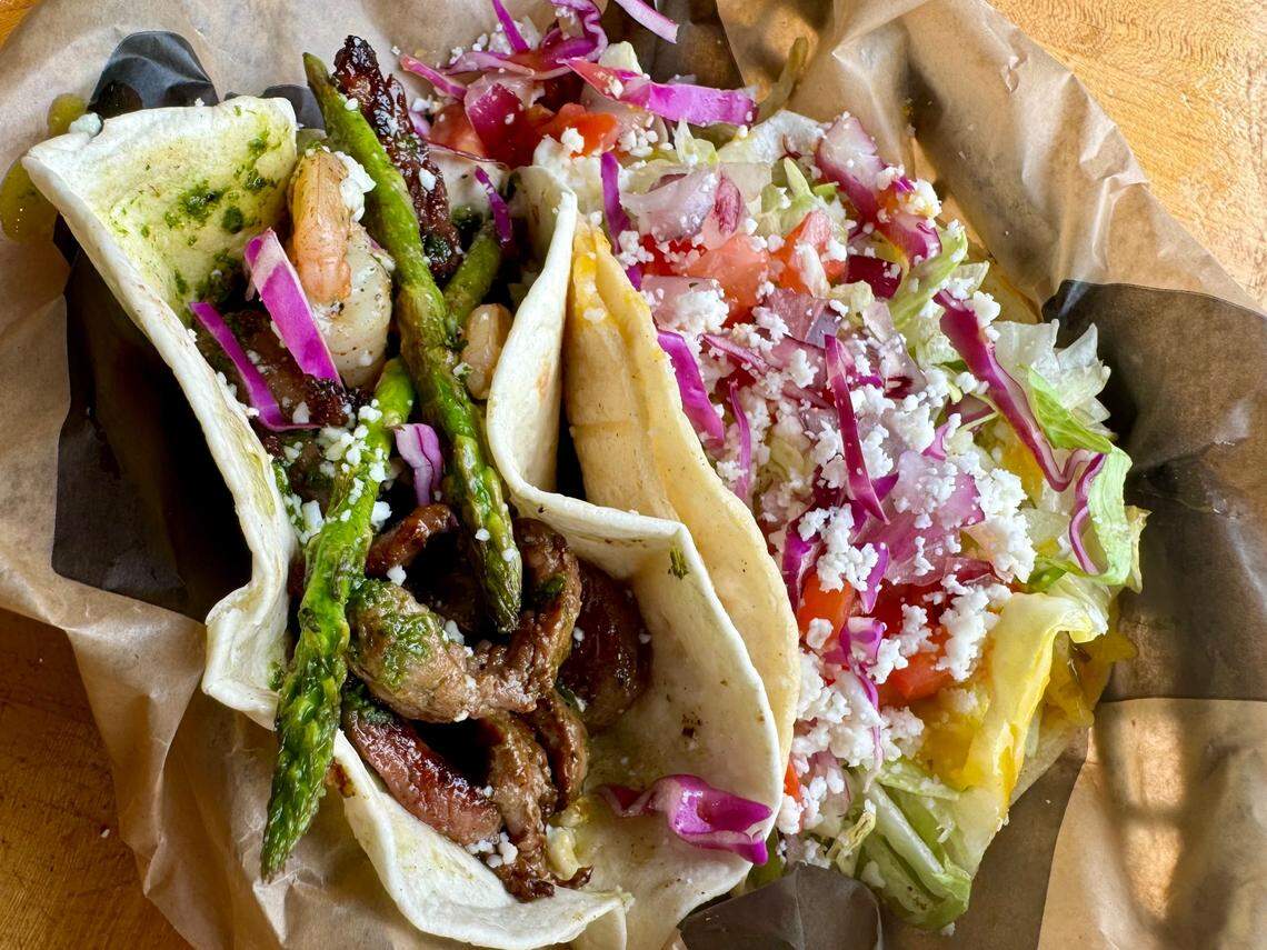 A steak-and-shrimp taco and a traditional habanero-mango shrimp taco at Tres Amigos Tacos and Tequila in Fort Worth.