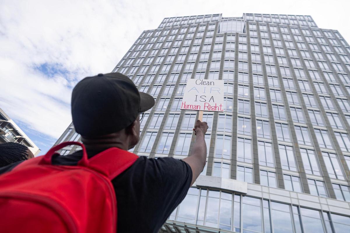 A protester holds a sign in support of the Echo Heights neighborhood outside of the City Hall building in downtown Fort Worth on Tuesday, June 10, 2025. FedEx applied for a conditional use permit to allow parking of semi-trucks and trailers in a part of the Echo Heights neighborhood, prompting a protest by the Fort Worth Environmental Coalition of Communities—a group of residents fighting environmental racism—urging the city to deny the permit.