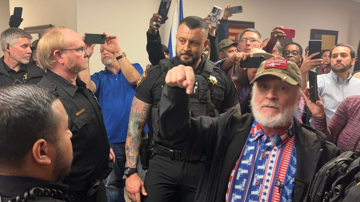 Christopher J. Grisham, a criminal defense and civil rights lawyer from Temple, argues with Tarrant County Sheriff’s Office deputies over his right to carry a gun in commissioners court on Jan. 14. Grisham was part of a group of conservative activists who came to demand justice for Mason Yancy, who died in the Tarrant County jail in December 2024, and call for the resignation of Sheriff Bill Waybourn.