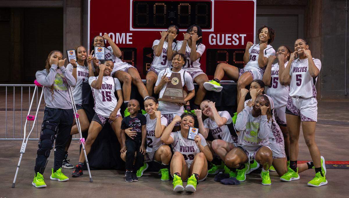 The Mansfield Timberview girls basketball team poses in front of a scoreboard after a 44-35 win over Argyle in the Class 5A Region I championship game on Saturday, February 24, 2024 at the Yeager Coliseum in Wichita Falls, Texas.